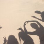 friends at the beach making silly shadows