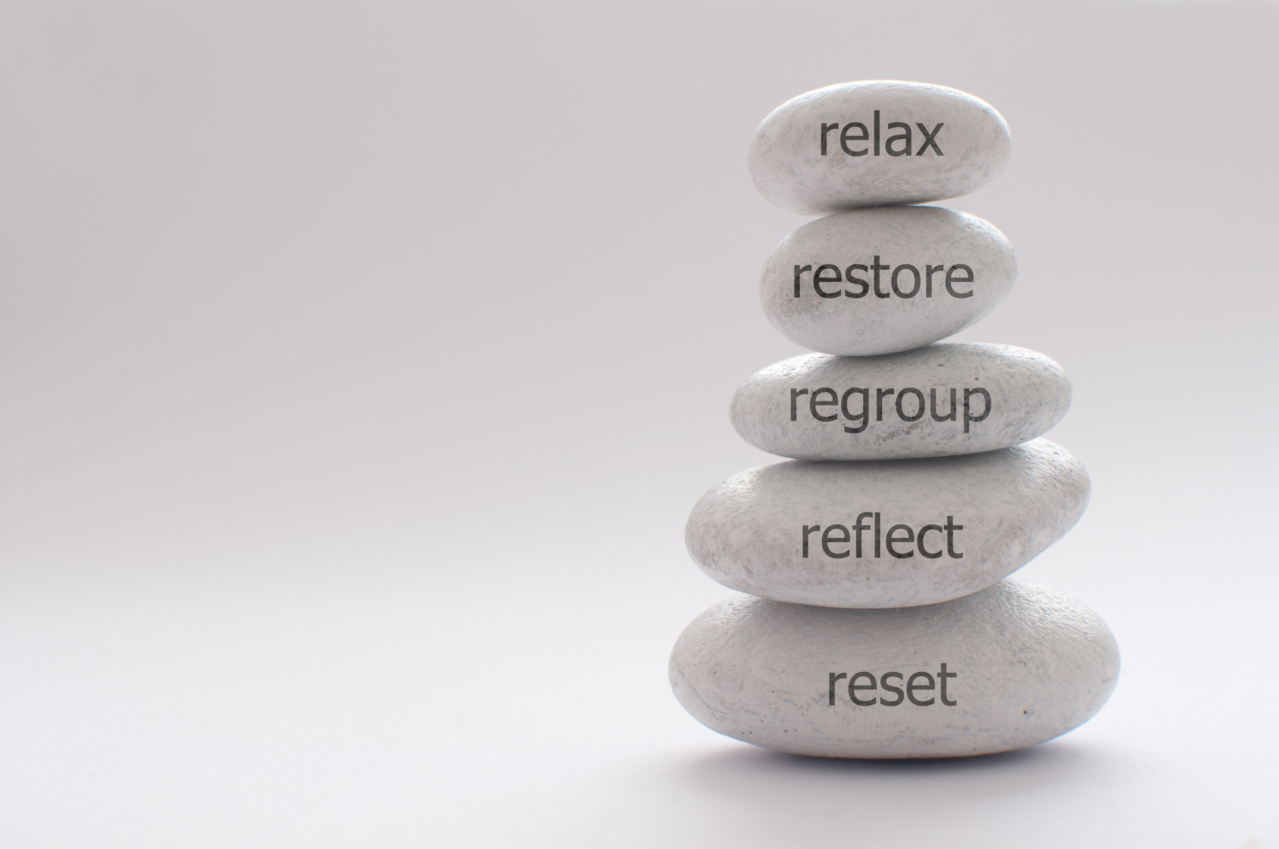 Grey balance rocks stacked on top of each other, each engraved with words symbolizing the emotional relief and clarity experienced after anxiety therapy.